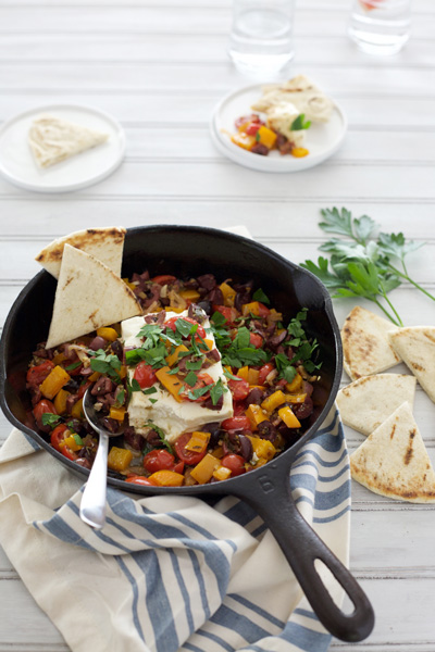 Grilled Feta Cheese with Olives and Tomatoes | BourbonandHoney.com -- Hot and melty, this grilled feta cheese is topped with olives, tomatoes and peppers for a quick and easy appetizer.