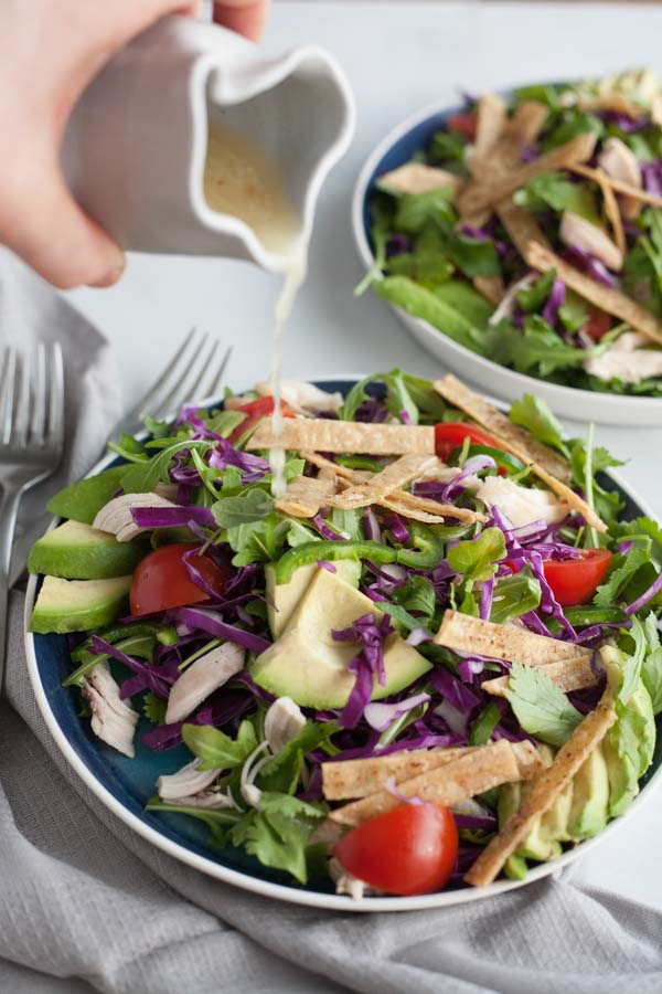 Avocado and Chicken Tortilla Salad | BourbonandHoney.com -- This Avocado and Chicken Tortilla Salad is piled with avocado, spicy jalapeño, crunchy tortilla strips and a bright lime dressing for a hearty weeknight salad.