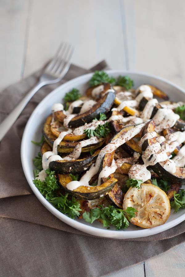 Roasted Acorn Squash with Tahini Yogurt Sauce | BourbonandHoney.com -- Seasonal Roasted Acorn Squash with Za’atar seasoning and a Tahini Yogurt Sauce; a flavorful and healthy side dish!