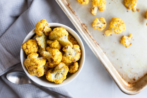 Curry Roasted Cauliflower | BourbonandHoney.com -- Super simple but flavorful and delicious, this Curry Roasted Cauliflower is a tasty side paired with chicken, pasta or added to a salad.