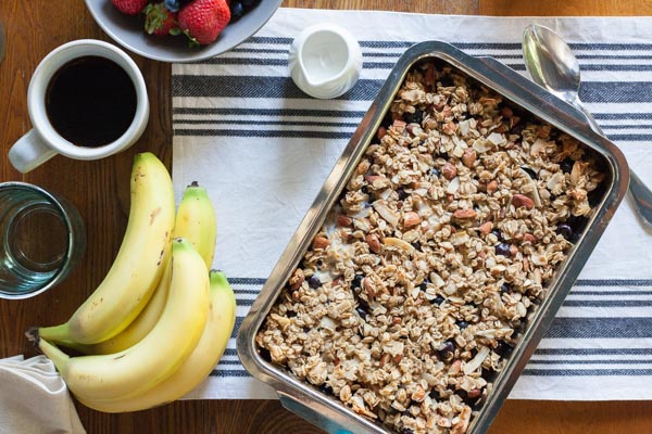 Coconut Baked Oatmeal with Berries | BourbonandHoney.com -- A warm, fruity and hearty Coconut Baked Oatmeal with Berries, almonds and bananas. It's the perfect recipe for a lazy weekend brunch!