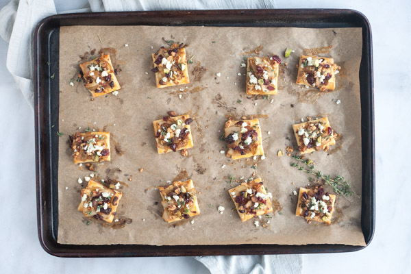 Caramelized Onion Apple Tarts with Blue Cheese and Cranberries | BourbonandHoney.com -- These super flavorful Caramelized Onion and Apple Tarts with Blue Cheese and Cranberries are the perfect bite sized appetizer!