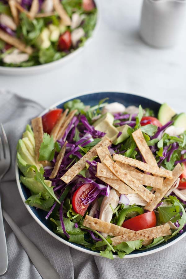 Avocado and Chicken Tortilla Salad | BourbonandHoney.com -- This Avocado and Chicken Tortilla Salad is piled with avocado, spicy jalapeño, crunchy tortilla strips and a bright lime dressing for a hearty weeknight salad.