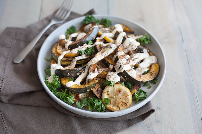 Roasted Acorn Squash with Tahini Yogurt Sauce | BourbonandHoney.com -- Seasonal Roasted Acorn Squash with Za’atar seasoning and a Tahini Yogurt Sauce; a flavorful and healthy side dish!