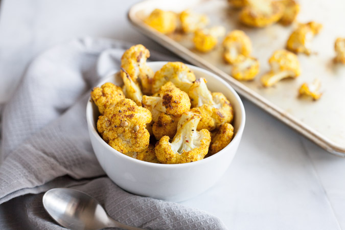 Curry Roasted Cauliflower | BourbonandHoney.com -- Super simple but flavorful and delicious, this Curry Roasted Cauliflower is a tasty side paired with chicken, pasta or added to a salad.