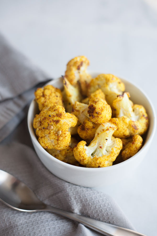 Curry Roasted Cauliflower | BourbonandHoney.com -- Super simple but flavorful and delicious, this Curry Roasted Cauliflower is a tasty side paired with chicken, pasta or added to a salad.