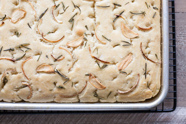 Garlic Rosemary Focaccia Bread | BourbonandHoney.com -- Garlicky, herby and delicious, this Rosemary Focaccia Bread is soft, rich and chewy and perfect for pizza crust, snacking or sandwiches.