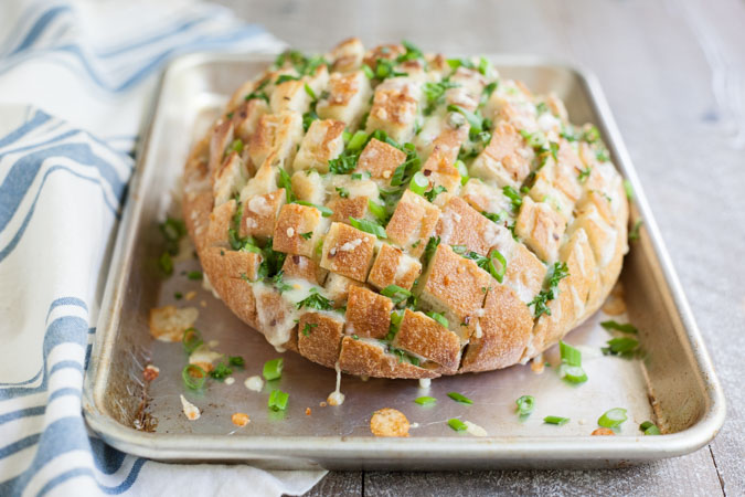 Cheesy Pull-Apart Garlic Bread | BourbonandHoney.com -- This over-the-top Cheesy Pull-Apart Garlic Bread is super cheesy, garlicky and totally delicious! Make it as a side with dinner or as a tasty appetizer.