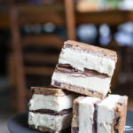 Nutella and Chocolate Chip Cookie Ice Cream Sandwiches | BourbonandHoney.com -- These simple, 3-ingreditent Chocolate Chip Cookie Ice Cream Sandwiches are layered with Nutella and a great way to cool down a crowd with an indulgent summer treat.