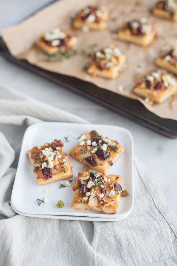 Caramelized Onion Apple Tarts with Blue Cheese and Cranberries | BourbonandHoney.com -- These super flavorful Caramelized Onion and Apple Tarts with Blue Cheese and Cranberries are the perfect bite sized appetizer!