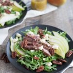 Arugula Flank Steak Salad with Pears and Blue Cheese | BourbonandHoney.com -- Filling, savory and delicious, this Flank Steak Salad recipe is topped with fresh pears, toasted pecans and lots of blue cheese and perfect for lunch or dinner!