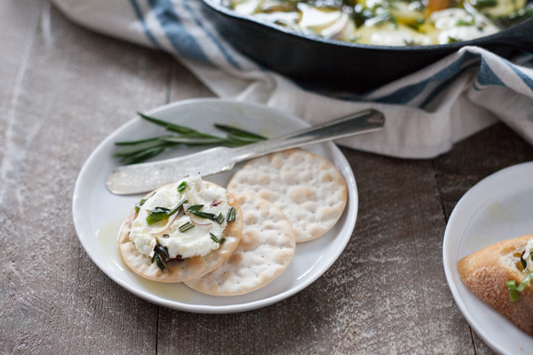 Baked Goat Cheese with Garlic and Herbs | BourbonandHoney.com -- This Baked Goat Cheese with Garlic and Herbs recipe is a quick and flavorful appetizer for a crowd. Besides being super easy, you can also make it ahead of time so you can really enjoy the party!